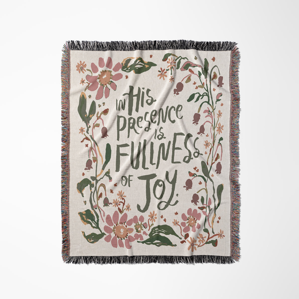A square woven throw blanket with fringe edges, featuring the phrase 'In His Presence is Fullness of Joy' in dark green script, surrounded by pink and green floral illustrations on a light beige background.
